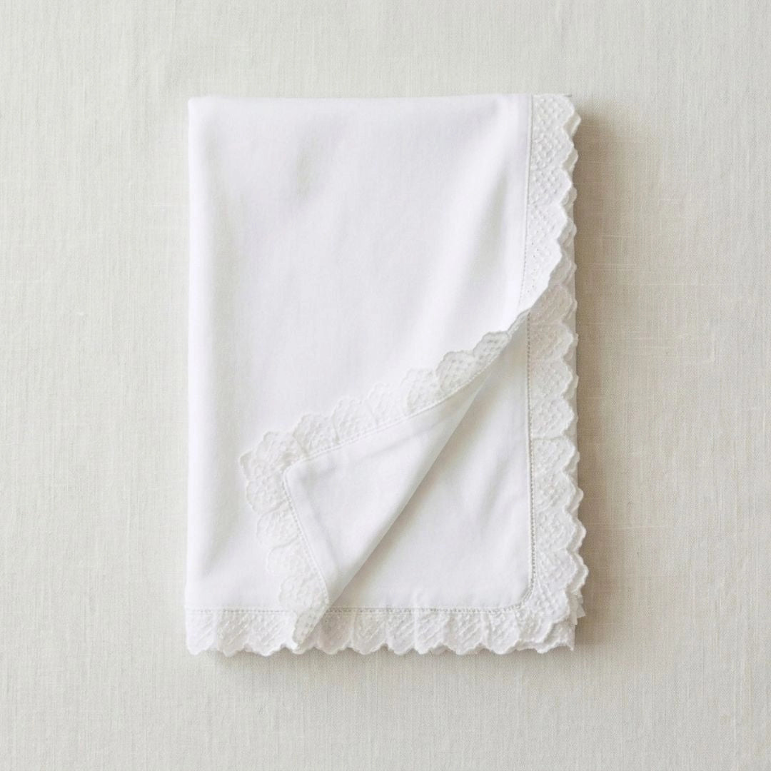 White napkin with lace trim on a light beige background