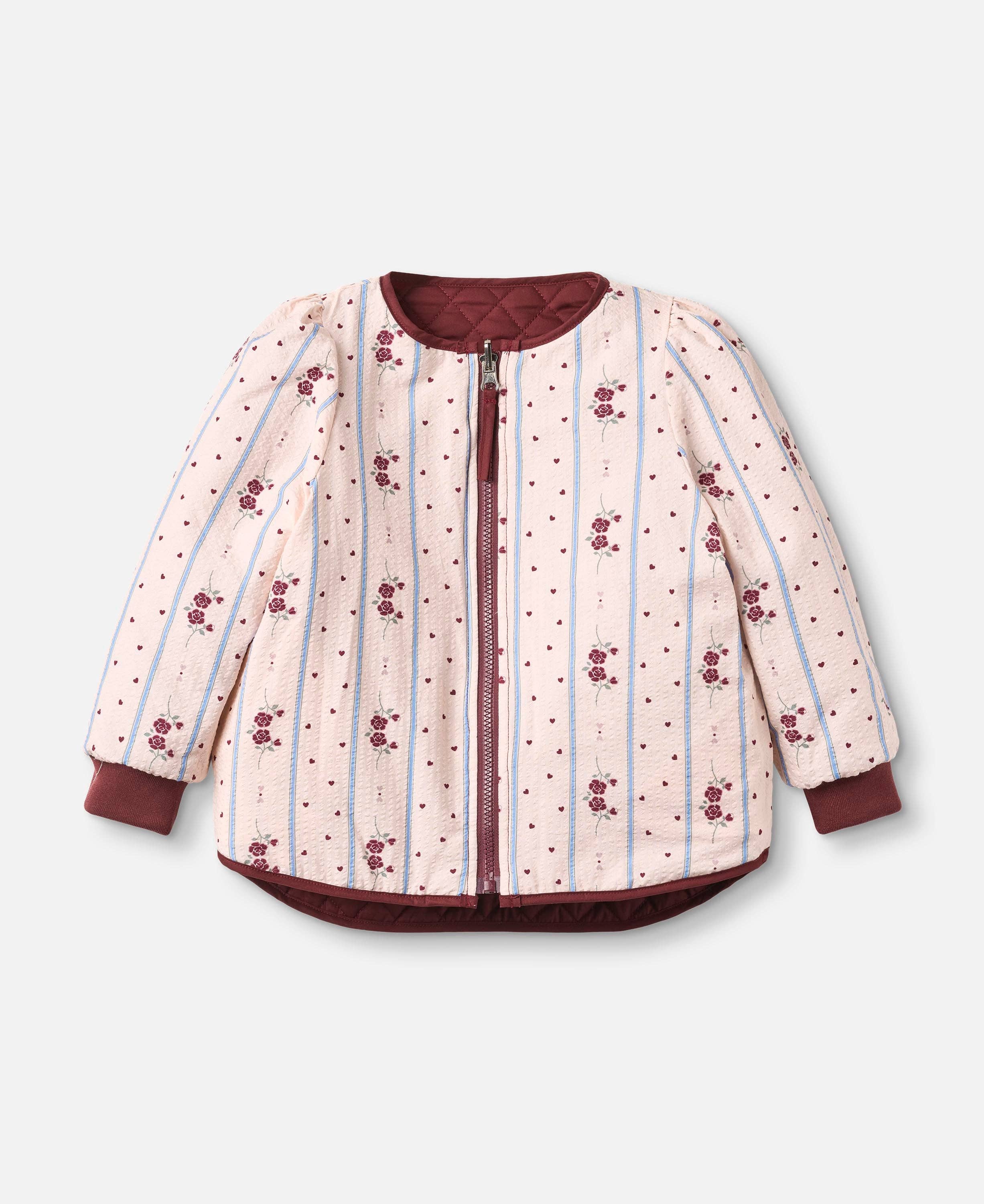A children's quilted jacket with a light pink and white striped pattern, decorated with small red floral motifs and tiny red dots. It features solid dark red cuffs, hem, and collar, and a matching dark red zipper.