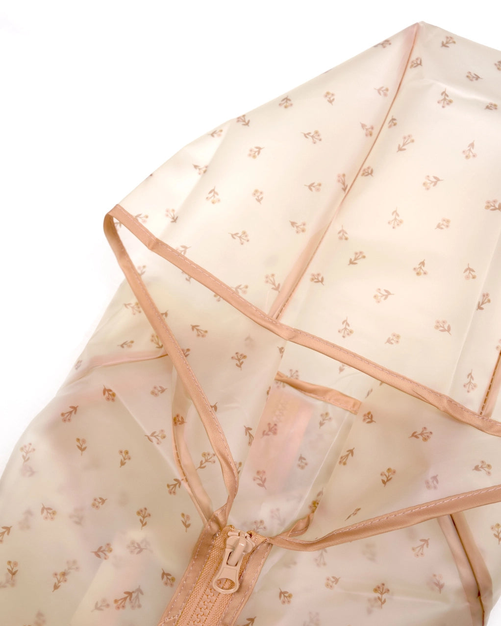 A close-up of a semi-sheer beige garment bag with a small floral pattern and peach-colored zipper trim, shown on a white background.