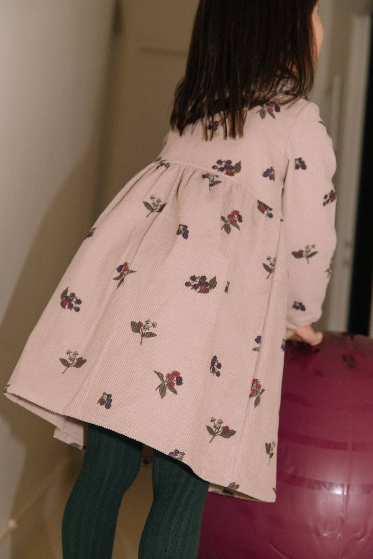 Person wearing a light pink floral dress with a blurred background