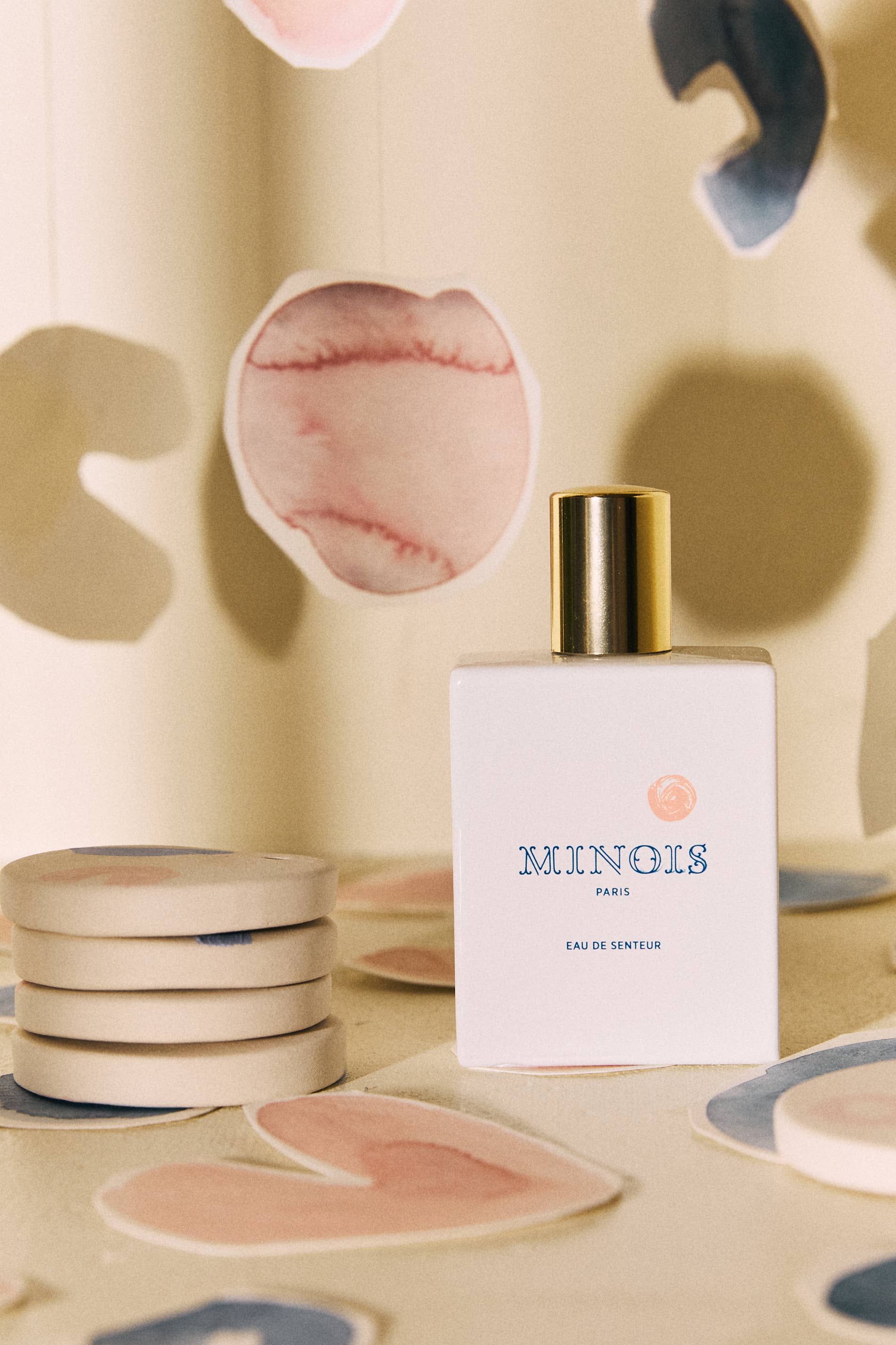 Perfume bottle labeled 'Minois' on a decorative surface with abstract designs.