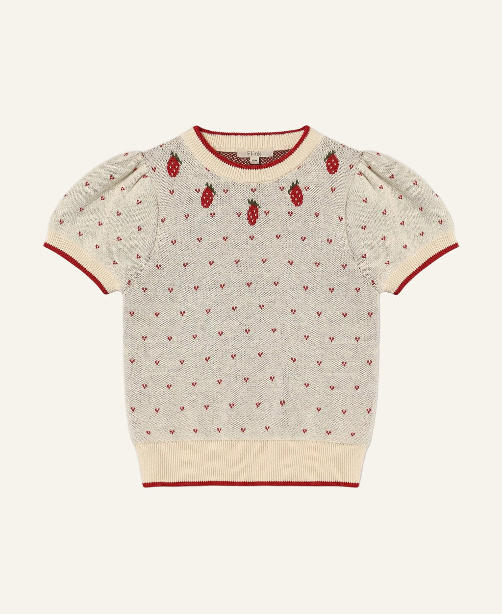 A cream-colored short-sleeve knit sweater with red trim, featuring a pattern of tiny red hearts and three embroidered strawberry motifs on the chest, displayed flat against a light gray background.