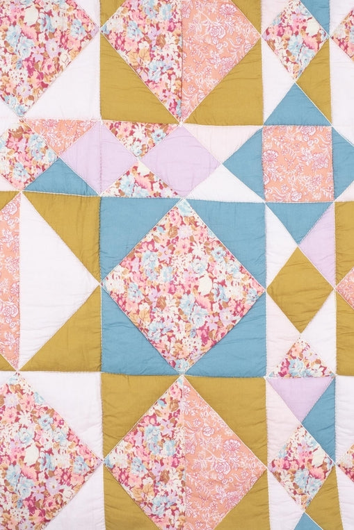 Quilt with diamond pattern featuring floral and solid colors