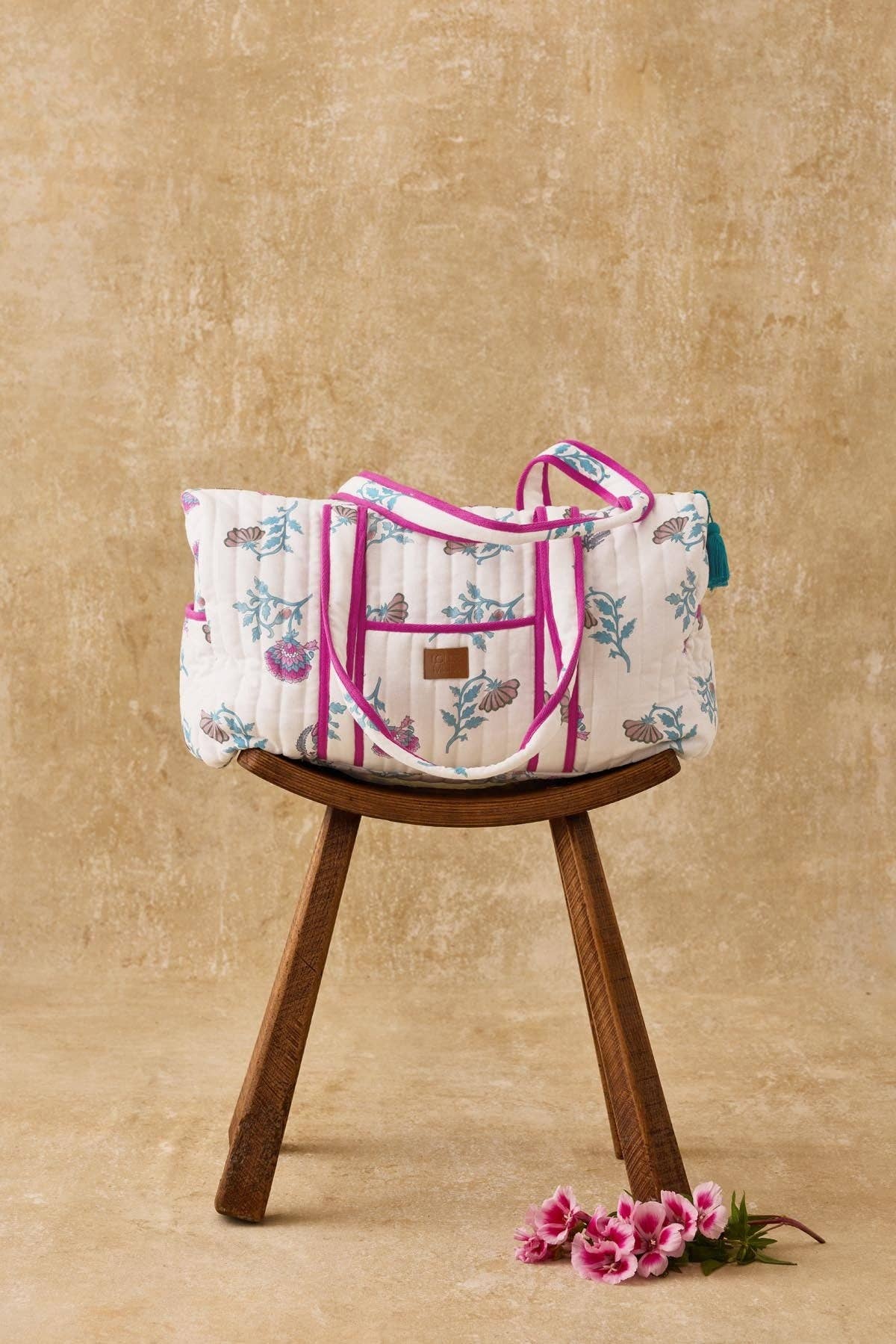 Floral-patterned bag on a wooden stool with a beige background