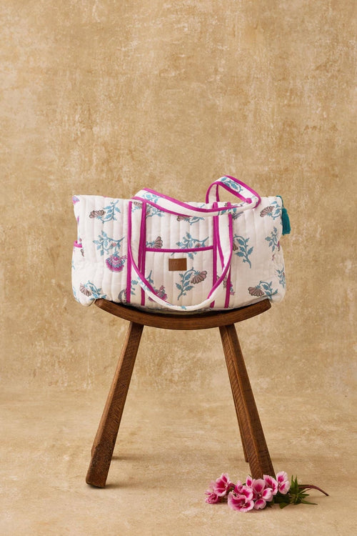 Floral-patterned bag on a wooden stool with a beige background