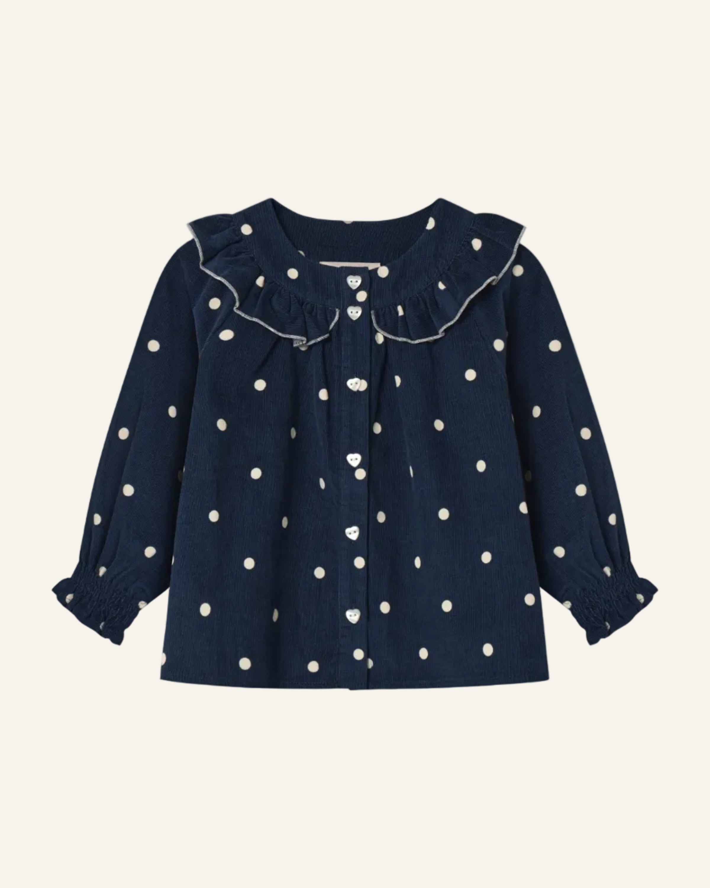 A navy blue long-sleeve blouse for toddlers, featuring a white polka dot pattern, a large ruffled collar, and a button-up front, shown against a light gray background.
