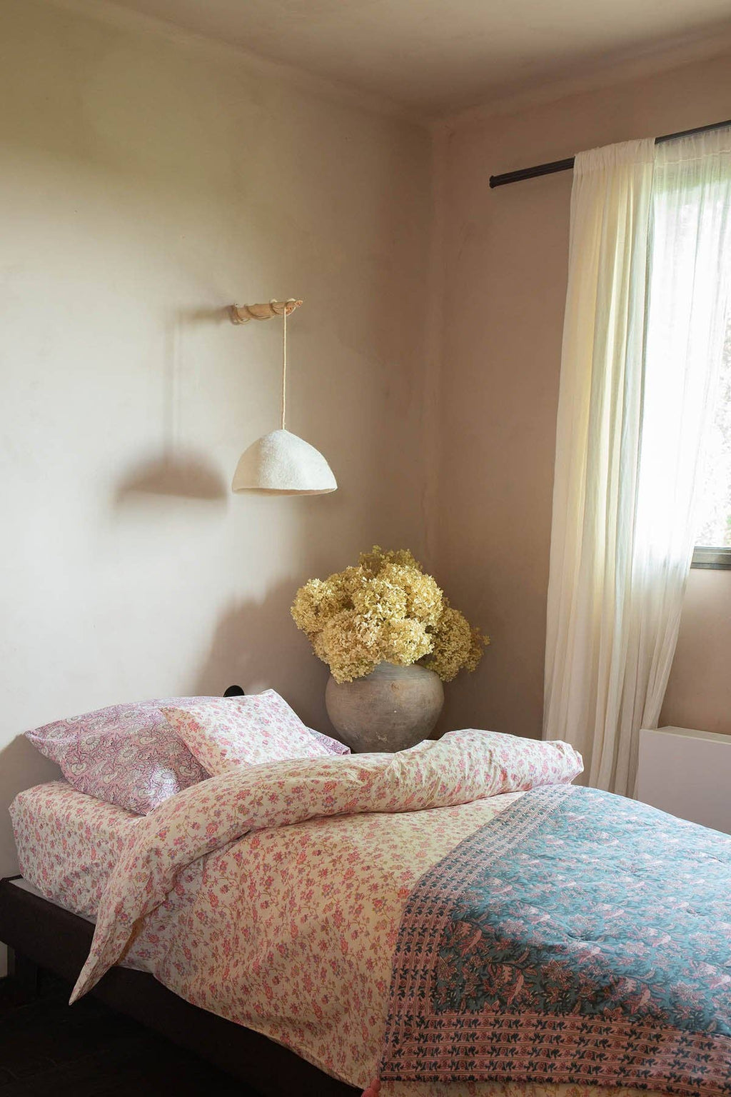 Bedroom with floral arrangement and wall light fixture