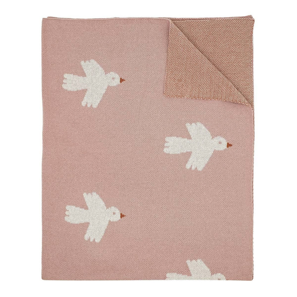 Pink blanket with white bird patterns on a white background