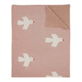 Pink blanket with white bird patterns on a white background