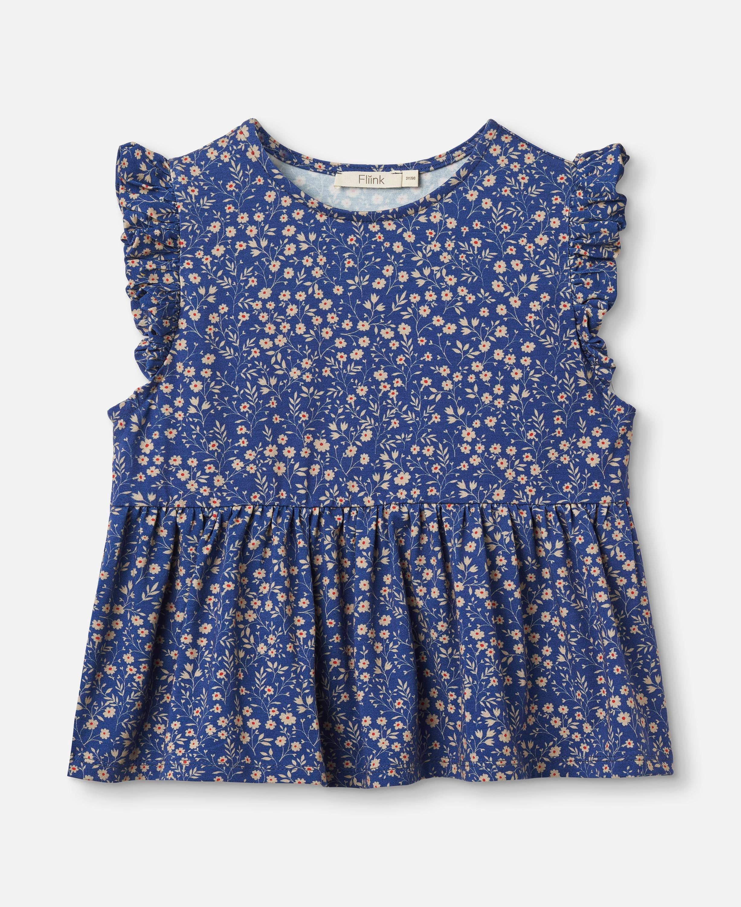 A sleeveless blue children's top with a dense small floral print, ruffled shoulders, and a gathered waist seam, shown flat against a light gray background.