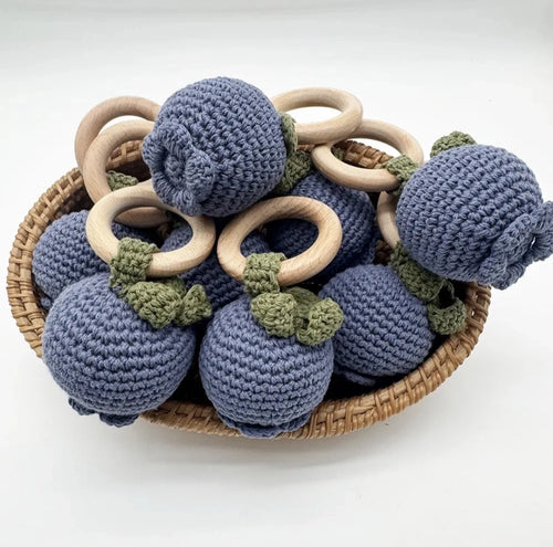 Basket of blue crocheted balls with wooden rings on a white background