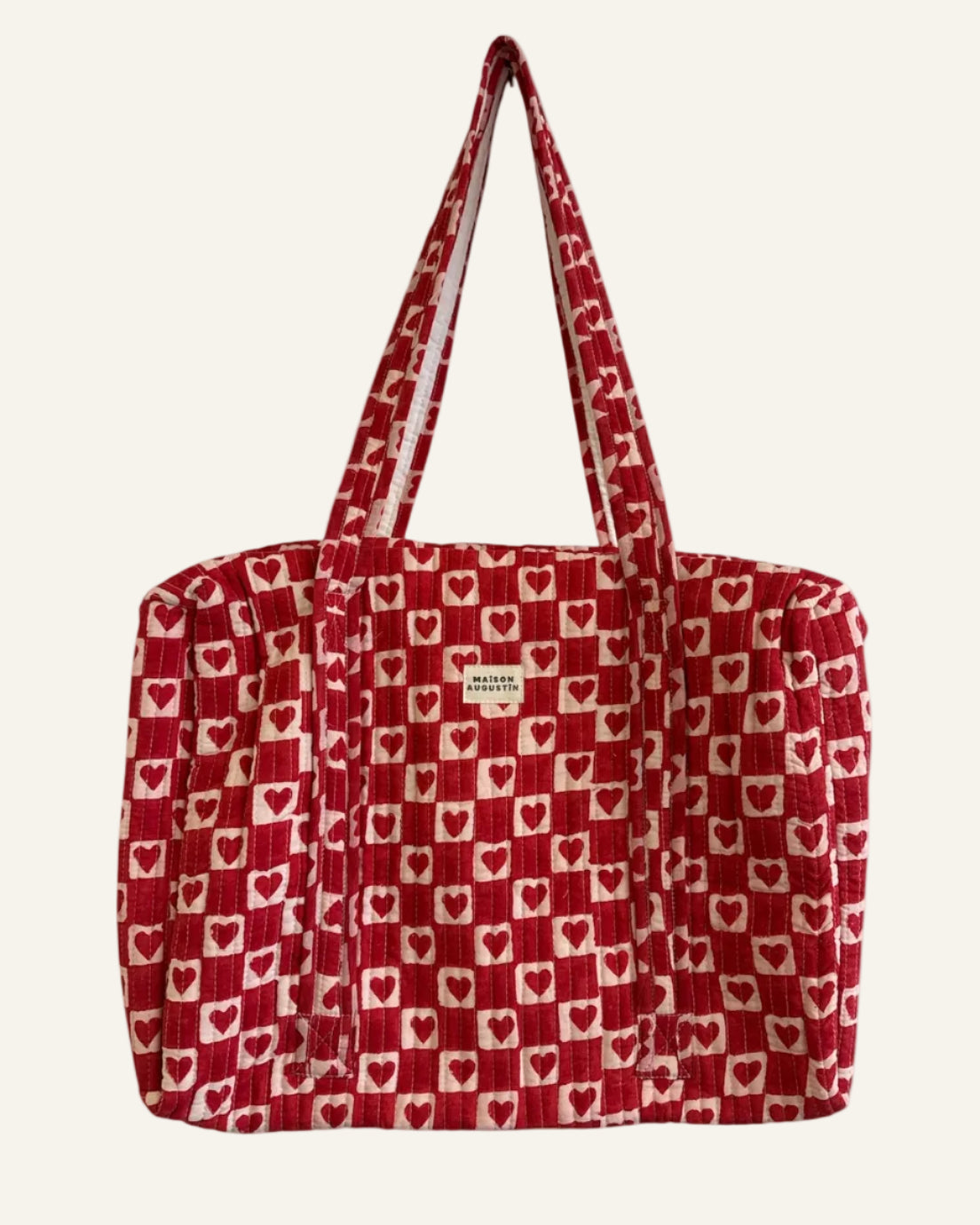 Red tote bag with heart pattern on a white background