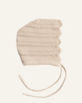 Knitted beige baby bonnet on a white background