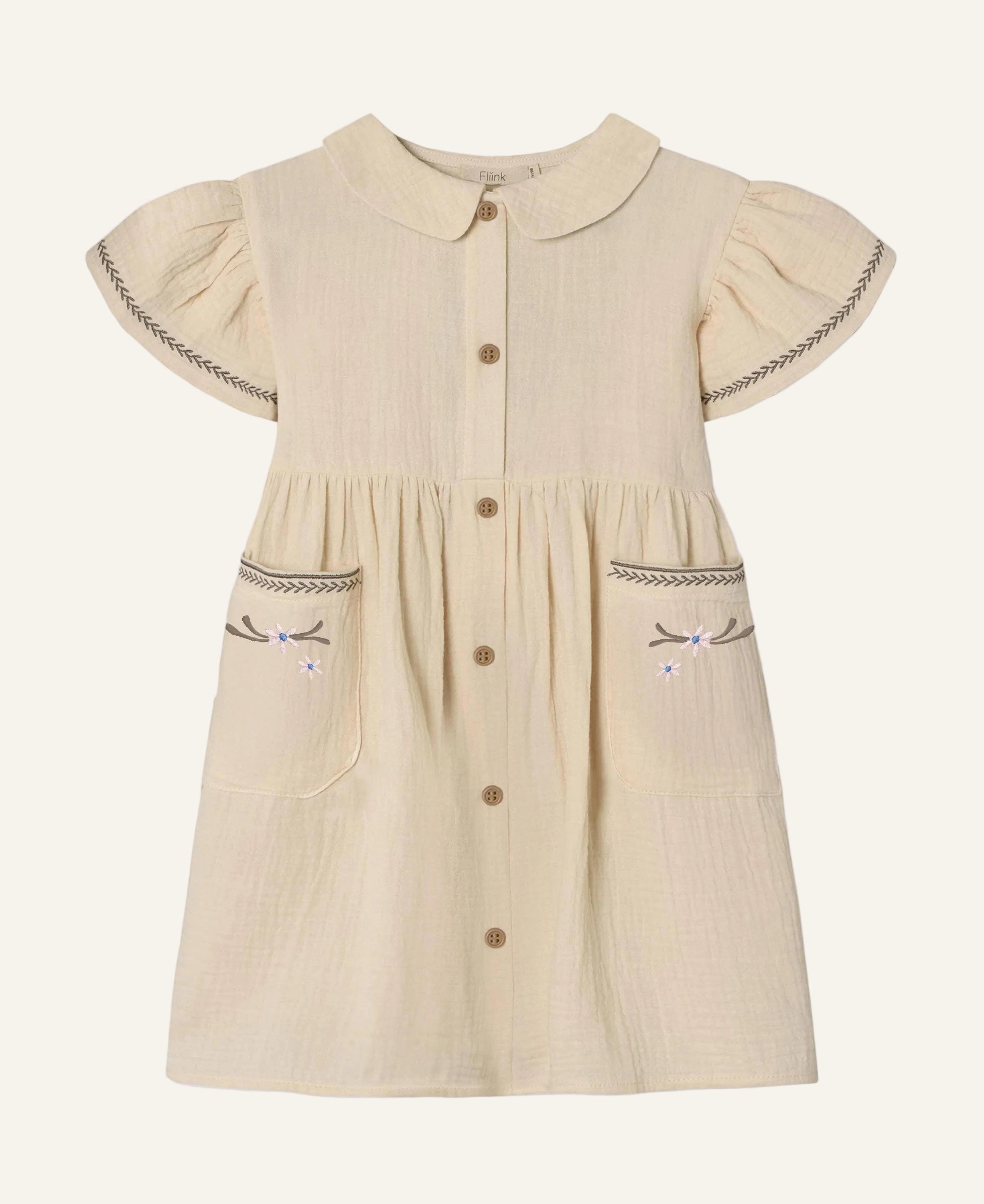 A cream-colored cotton gauze dress for toddlers, featuring a Peter Pan collar, short flutter sleeves with decorative stitching, a button-up front, and embroidered bow details on the front pockets.