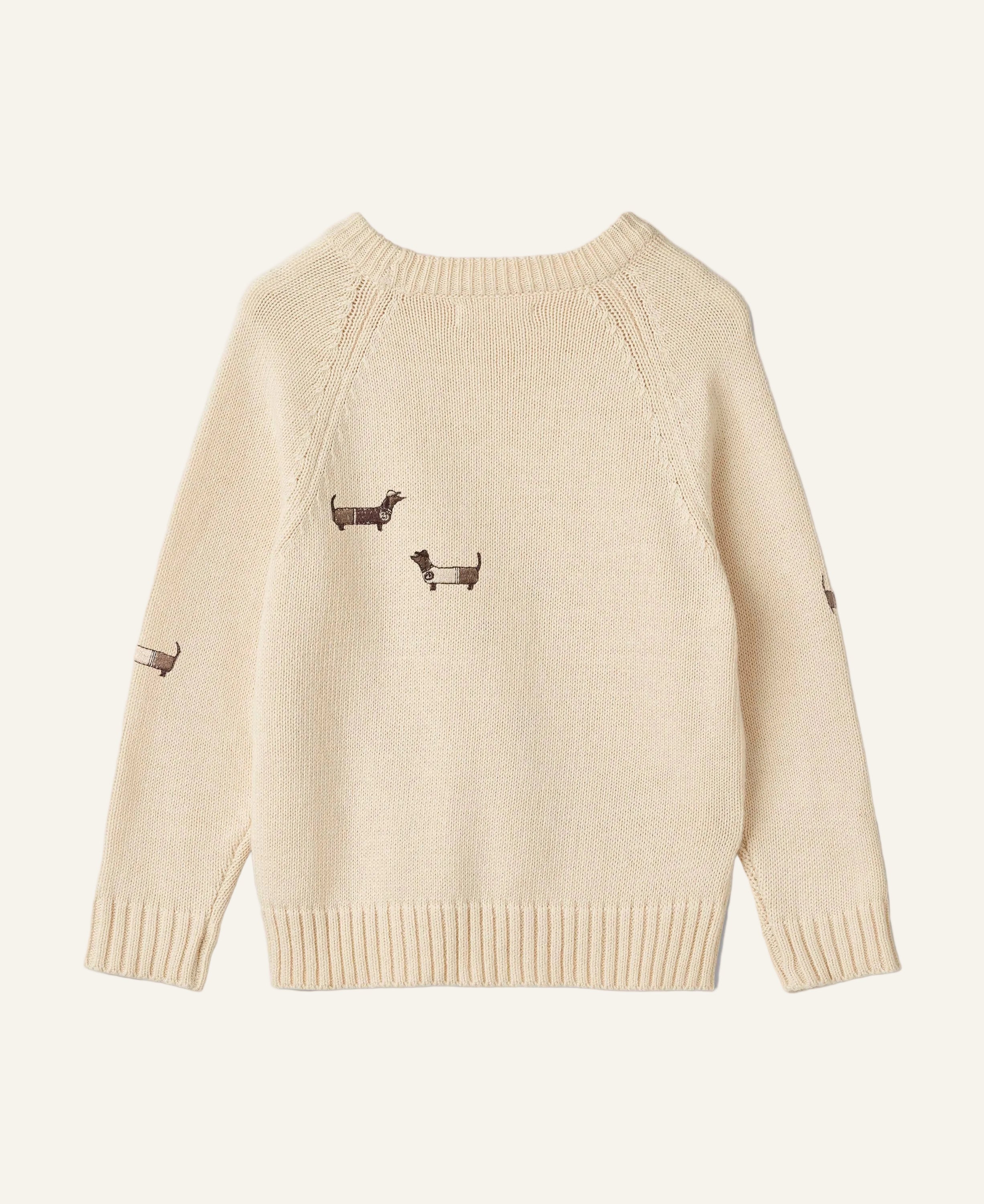 A cream-colored knit sweater with embroidered dachshund motifs on the chest and sleeves, displayed flat against a light gray background.