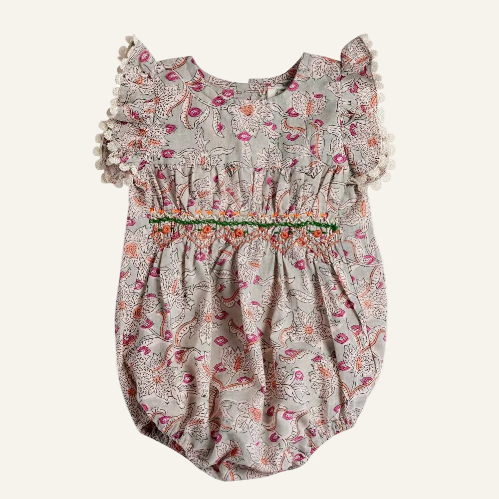 Floral baby romper with ruffled sleeves on a white background