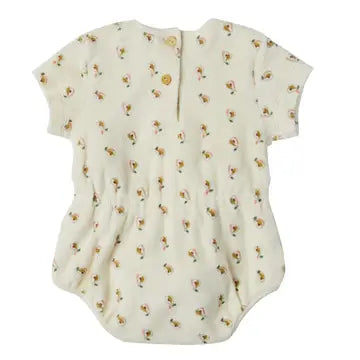 A short-sleeve baby bodysuit in cream with a small all-over floral print, featuring a snap closure at the neckline.
