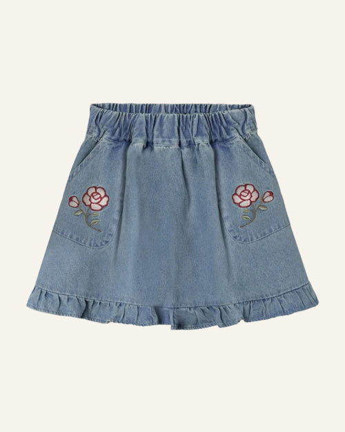 Denim skirt with floral embroidery on a light gray background