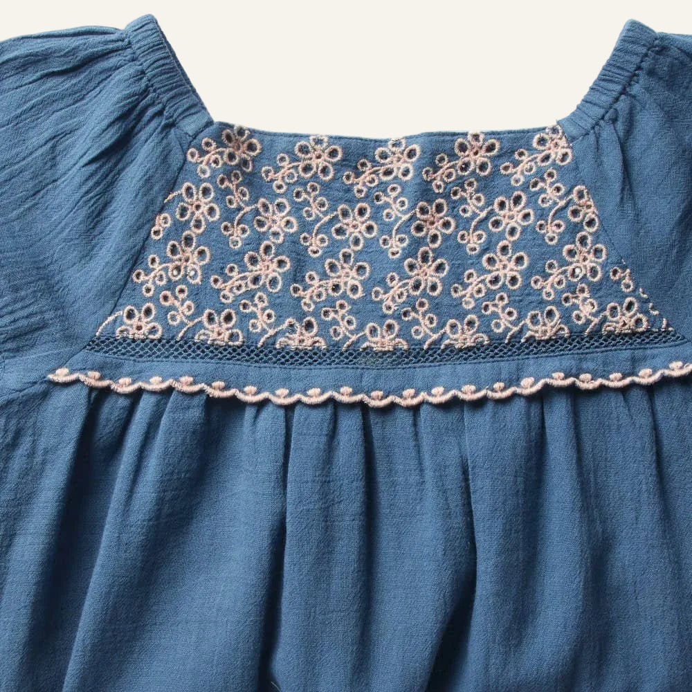Blue dress with floral lace detailing on a white background