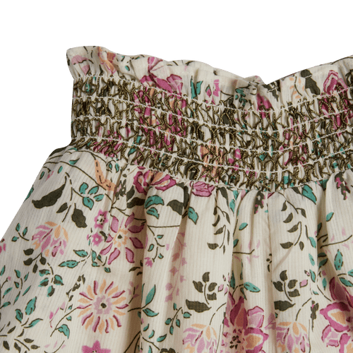Floral patterned fabric with smocked waistband on a green background