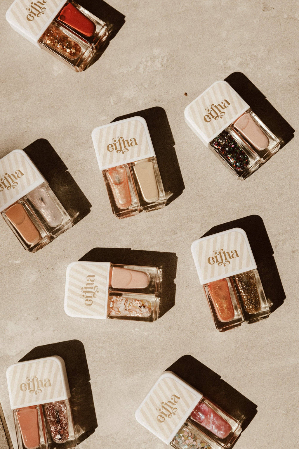 Multiple small nail polish containers with visible brand name on a textured surface