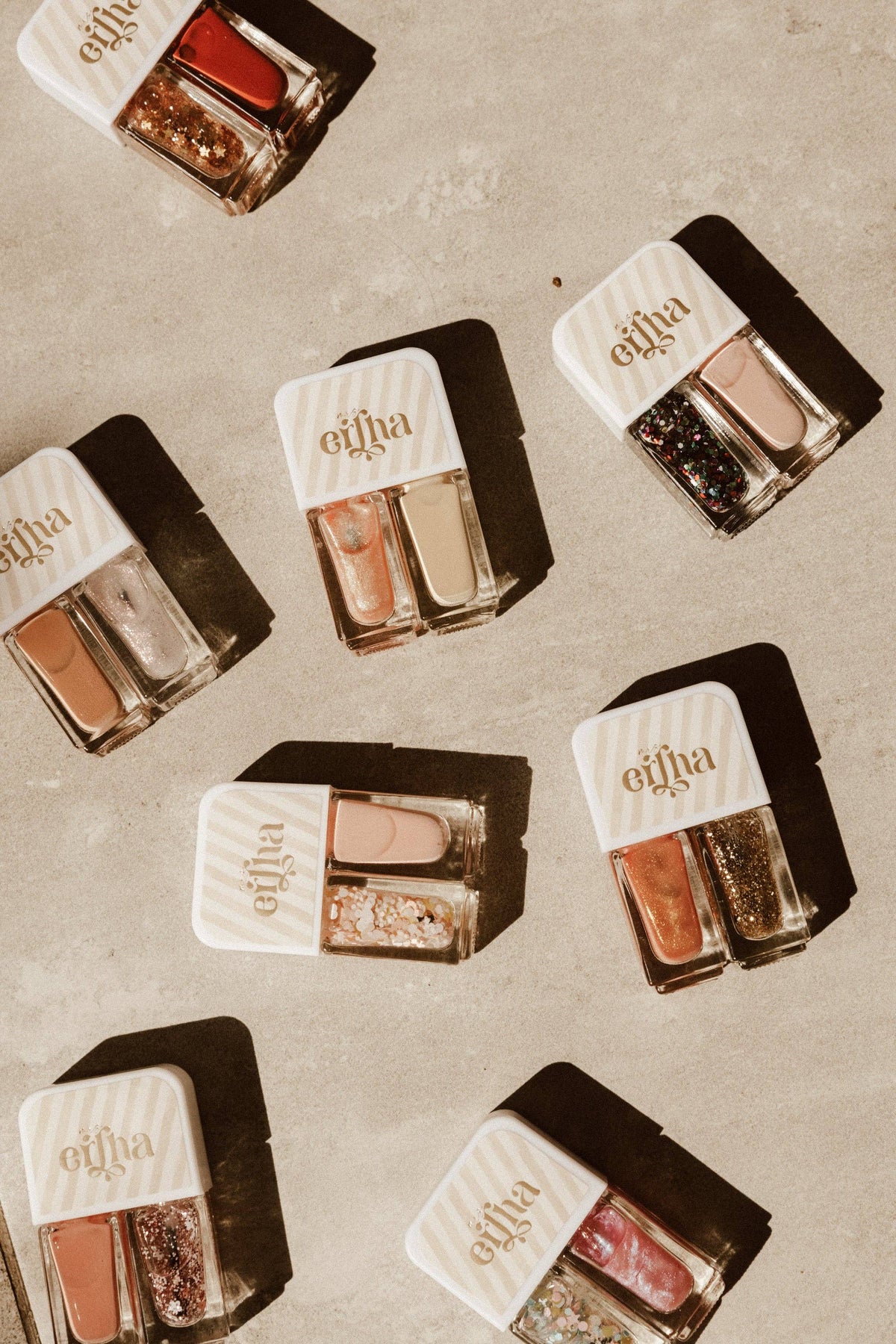 Multiple small nail polish containers with visible brand name on a textured surface