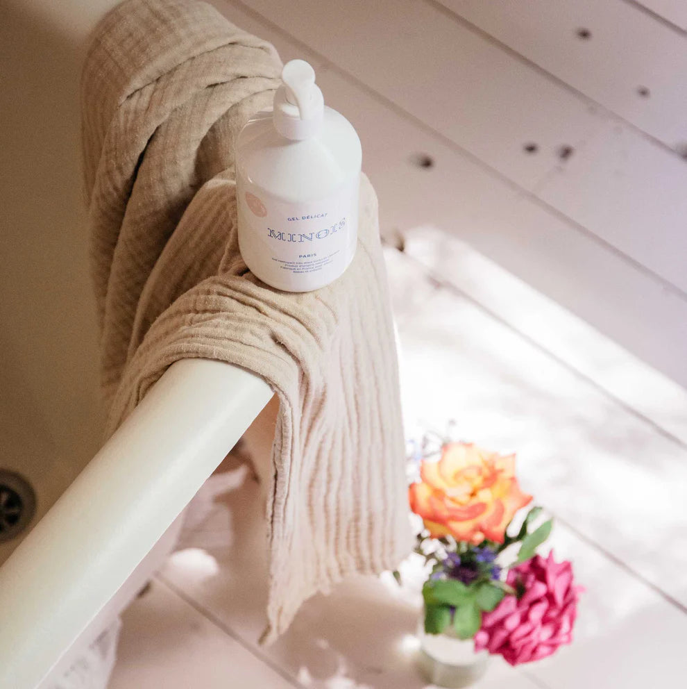 Bottle of hand sanitizer on a towel with flowers in the background