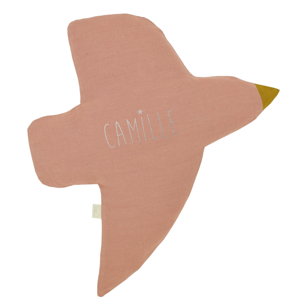 A soft, bird-shaped cushion in a dusty rose pink color, featuring the name 'CAMILLE' embroidered in white across the center and a small yellow beak on the right wingtip, set against a plain white background.