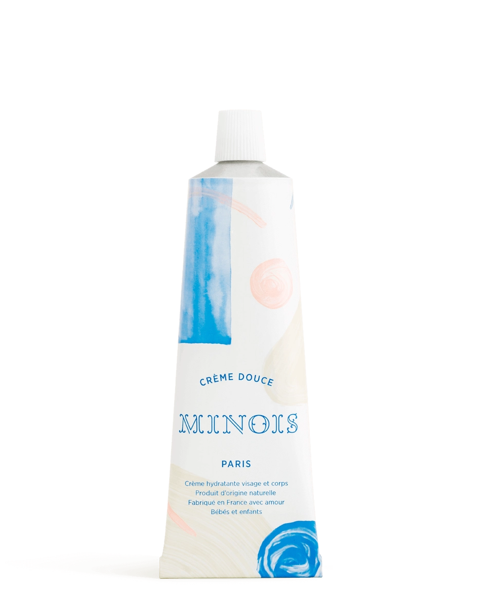 A squeeze tube of Minois Paris soft cream body butter with a white cap, featuring a white label with blue and pink abstract watercolor details, set against a plain white background.