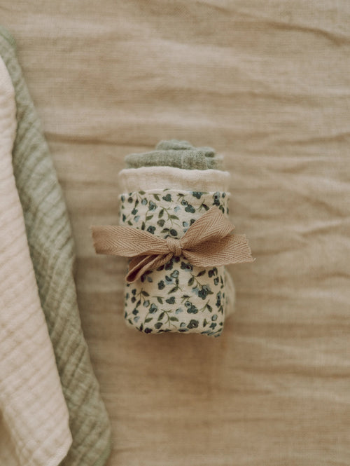Folded fabric with a floral pattern and brown ribbon on a beige background