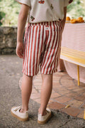 Person wearing red and white striped shorts standing outdoors.