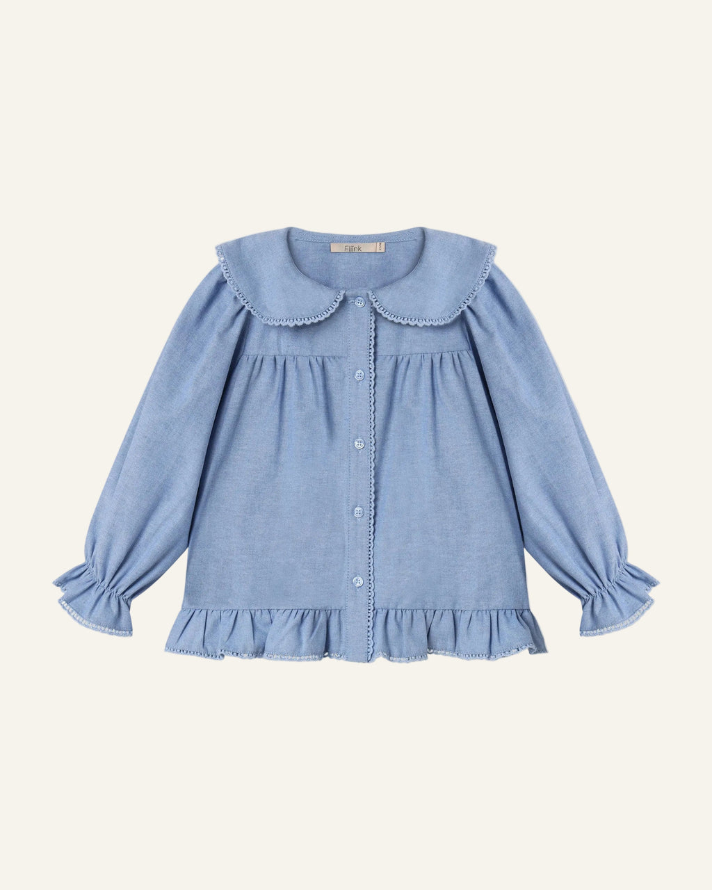 A light blue long-sleeve blouse for toddlers, featuring a large Peter Pan collar, button-up front, and ruffled trim at the hem and cuffs, shown flat on a light gray background.