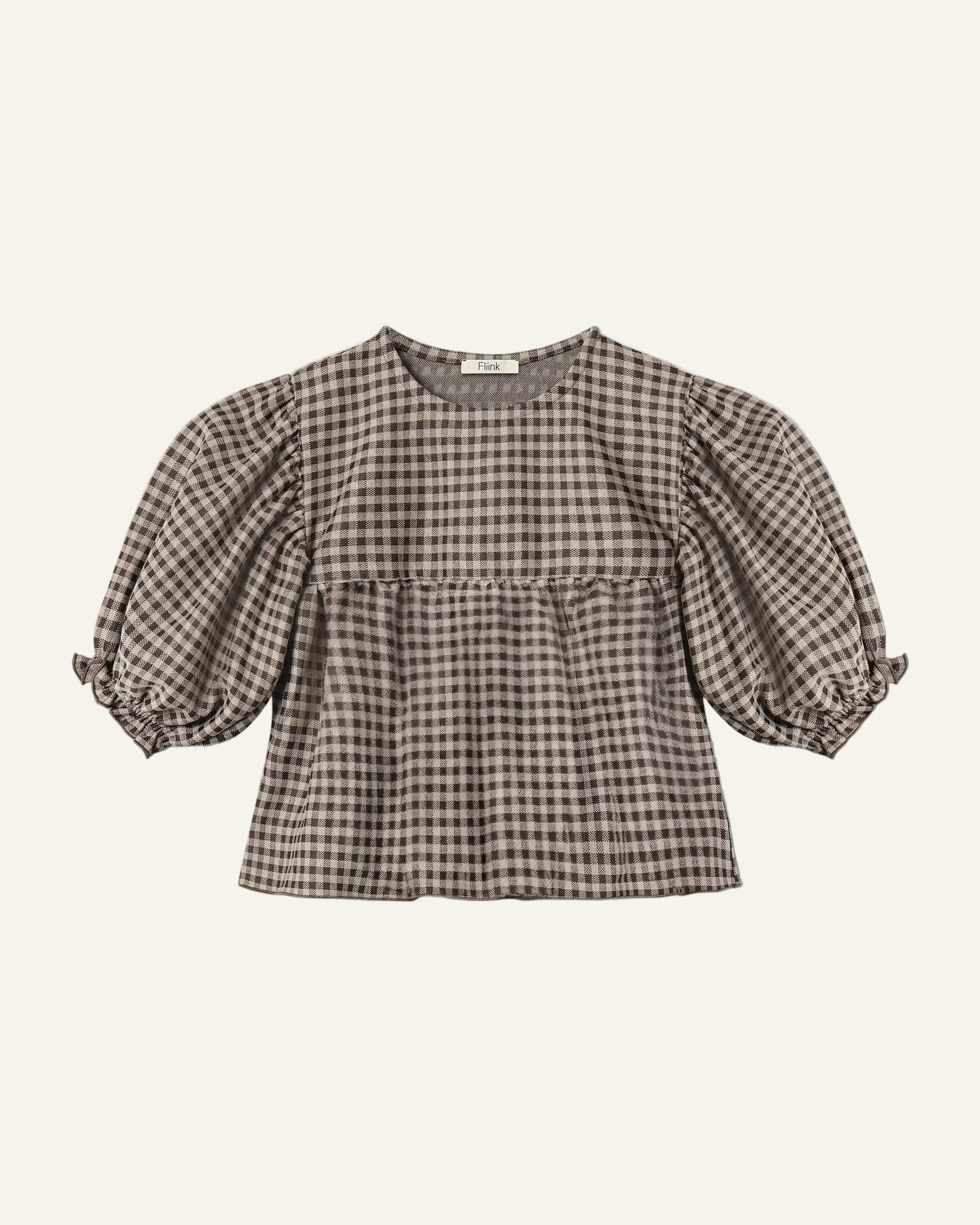 A brown and beige gingham check short-sleeve blouse with puffed sleeves and a ruffled hem, shown flat on a light gray background.