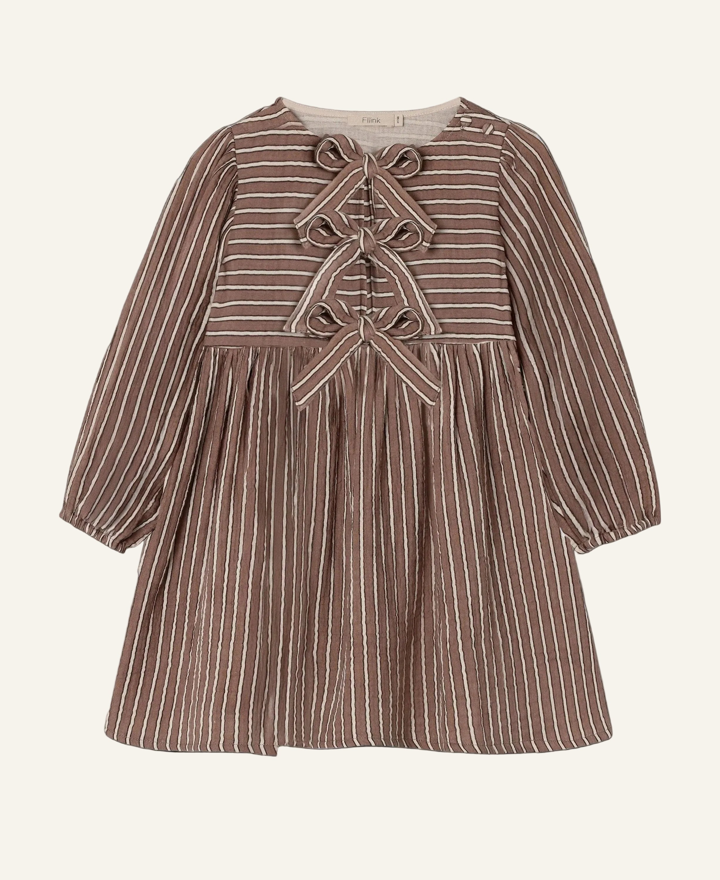 A long-sleeve baby dress in brown and beige vertical stripes, featuring a lace-up front detail and a gathered waist, shown against a light gray background.