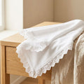 White lace-trimmed towel on a wooden bench