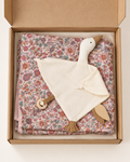 A baby comforter set in a kraft gift box, featuring a cream-colored goose-shaped security blanket with a wooden teething ring and a folded pink, red, and blue floral patterned blanket underneath.